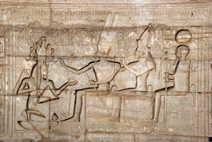 エジプトの古代遺物：ファラオ・ラムセス2世がテバン族の三神（アモン、ムート、コンス）の前にいる様子を描いたレリーフ；ファラオ・ラムセス2世（前1279-1213）を祀った葬祭殿（エジプト・ルクソールのラマッセウム遺跡 作： Egyptian 19th Dynasty