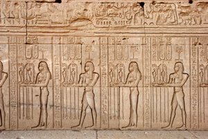 エジプトの古代文明：女神に捧げられた供物と貢物（エジプト、デンデラのハトホル神殿） - エジプトの文明：女神に捧げられた供物と貢物 - デンデラのハトホル神殿（またはテンティラ神殿）の壁に彫られた人物像。