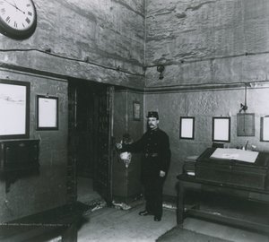 刑務所の看守がエントランスホールのドアのそばに立っています
