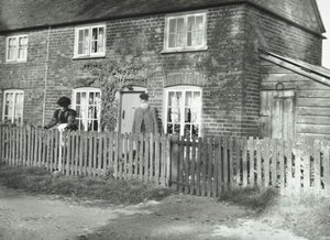 1895年にロンドンのコテージスタイルの建物の庭に老夫婦がいるウォンズワースエリアの田園風景