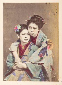 伝統的な衣装を着た日本の女性、 2 人の若い女性の 4 分の 3 の長さの肖像画。1 人は座っており、もう 1 人は肩に寄りかかって腕を回している。  撮影者：不明  ルーカス コレクション: チャールズ ジャのワールド ツアーの写真記録 作： English Photographer