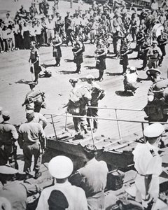 1950年8月29日、釜山のHMSセイロンからアーガイル・アンド・サザーランド・ハイランダーズ第1大隊に上陸したキルト・パイパーの演奏（モノクロ写真 作： English Photographer