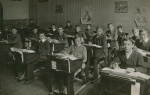 学校の授業中に机の後ろに座っている男性生徒