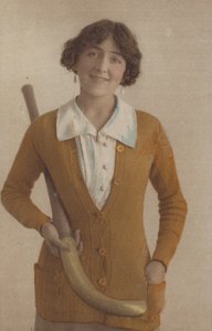 ニットのジャンパーを着て、パールのイヤリングをして、ホッケーのスティックを持った可愛い女の子（写真 作： English Photographer