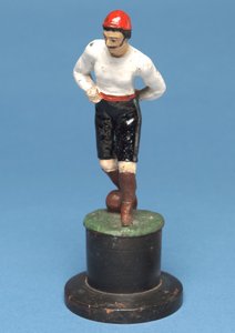 足にボールを持ったフットボール選手（手描きの金属） 作： English School