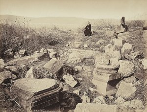 僧侶と銃を持った男が遺跡に座ってポーズをとっている（カファルナウム近郊 作： Félix Bonfils
