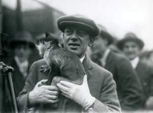1925年にロンドン動物園の外部放送に参加した、ハンドラーと一緒の黒いクレステッドマンガベイ、おそらくそばかす 作： Frederick William Bond