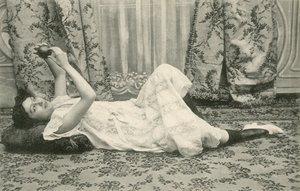 床に寝そべってボールを頭の上に持っている女の子（モノクロ写真 作： French Photographer