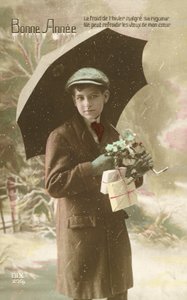 傘を持って雪の中に立つ、ハンサムで身なりの良い少年（カラー写真 作： French Photographer