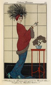 Manteau de Damas rose garni de Renard bleu Coiffure de Paradis noirs. コスチューム パリジェンズ no.35。 女性は、青い模様のドレスの上に毛皮の裏地が付いたダマスカスピンクのコートを着ており、青い石が付いた羽毛の頭飾りを着ています。 作： Georges Barbier