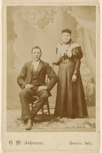 [身元不明のカップル：口ひげを生やした男が座り、女が立っている] 作： H. M. Johnson