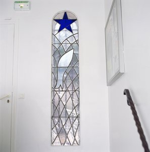 救いの星の下、網にかかった魚を描いたステンドグラス（ロザリオの礼拝堂に続く階段より