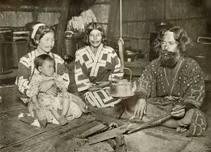 アイヌの男性と女性の自宅、1910年。 作： Herbert Ponting