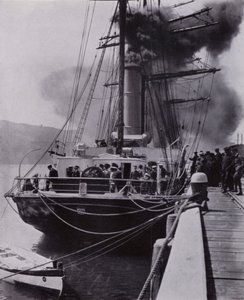 「小さな船が旅の最後にポート・チャルマーズを出発した」（モノクロ写真 作： Herbert Ponting