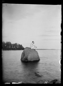 岩の上に座るフーゴ・シンバーグ、背景はエッサリとスオニオンサーリ 作： Hugo Simberg