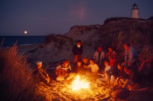 グレート・ポイント灯台で夏のキャンプファイヤーを囲む仲間たち。ナンタケット島... 作： James L Stanfield
