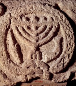 ユダヤ教：7つの枝を持つ燭台（メノーラ）、ヤシの木、トランペットで装飾されたシナゴーグの玄武岩の建築要素。トランスヨルダン産。紀元100年頃。パリ、ルーブル美術館 作： Jewish School
