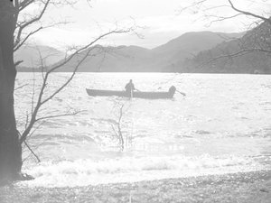 湖上でボートに乗り、釣りをする男性。