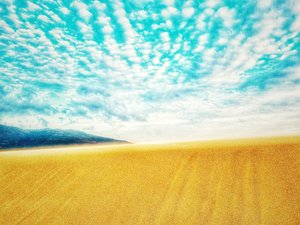 山脈の中の超現実的な砂漠のビーチ 作： Katha Wood