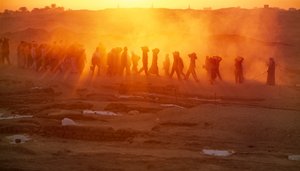アビドスの遺跡発掘で資材を運ぶ作業員たち。埃と...、2005年（写真）