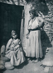 1912年、アルジェリアの地中海沿岸近くの住居の玄関にいるカビールの女性。 作： Kuhn