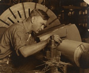マイクロメータで1/1000インチのシャフトを測定する男。 作： Lewis W. Hine