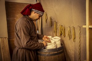 歴史を再現しています。14世紀半ば、イタリア・イモラのディオタイウティの薬屋で、ロウソクと小麦、ライ麦、大麦の袋が置かれていた(写真) 作： Unbekannt Unbekannt