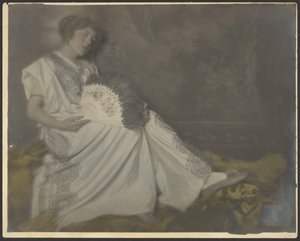 [大きな扇子を持って座るフローレンス】。］