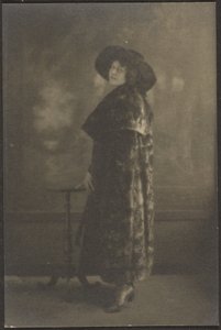 [タペストリーの前に長いコートを着た女性の肖像]。 作： Louis Fleckenstein