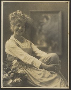 [花とピナフォアを着た女性の肖像]。 作： Louis Fleckenstein