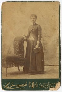 椅子の横に立って本を持っている女性の写真 19世紀後半 作： Louis Janousek