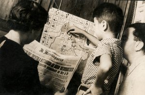 "アドワ奪還の勝利のトリコロールが揺れる "というタイトルのメッセンジャー紙の一面を読む女性。