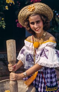 伝統的な乳鉢と乳棒で粉砕するパナマの麦わら帽子をかぶった女性。 作： Luis Marden
