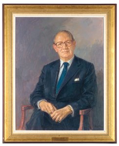 暗いスーツを着て座っているアルディントン卿の肖像画 作： Michael Noakes