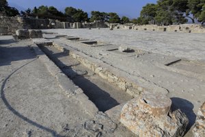 ミノア時代のファイストスの遺跡。西翼の祠堂から中庭を見たところ。中庭はミノアの宮殿の基本的な建築要素である。中庭は、ミノアの宮殿の基本的な建築要素であり、各翼を取り囲むように配置された核である。この中庭は、かつては 作： Minoan