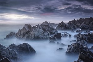 霧に包まれた海の岩場