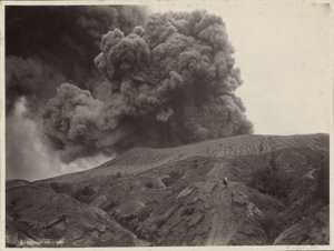 オランダ領東インドの煙る火山の近くで馬を持つ男
