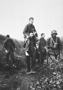 足を負傷したドイツ人歩兵がイギリス人捕虜に担がれて戦場を離れる様子（モノクロ写真