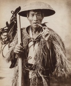 大雨の中、帽子をかぶって田んぼを歩く日本人クーリー（モノクロ写真 作： Photographer Japanese