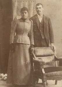 椅子の後ろに立っているアフリカ系アメリカ人のカップルの写真。 1890年。 作： Schmitz Studio