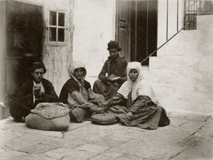 1867年にエルサレムの家の中庭で丸い石を使って小麦粉を挽いている女性