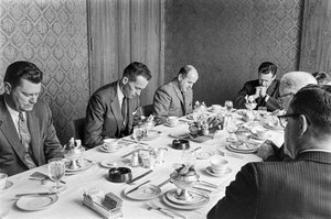 教会の資金集めの会合で、ランチを食べ始める前に祈るビジネスマンたち。 作： Ted Spiegel