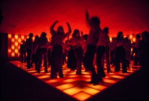 ライトアップされたフロアで踊るディスコ・ナイトクラブの若いダンサーたち 作： Ted Spiegel