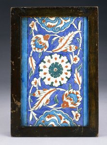 スクロールするパルメットと緑豊かなつるの間に中央の花頭があるイズニックボーダータイル、c.1570（セラミック）