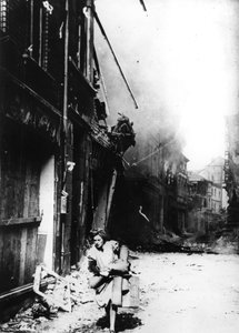 1945年にドイツの爆撃された通りに燃えている家を去る女性 作： Unbekannt