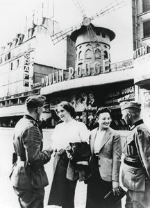 1940年6月、パリを占領したムーランルージュの外でフランス人女性とおしゃべりするドイツの兵士 作： Unbekannt