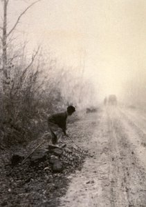 朝もやに包まれた田舎道。手前では男が石を割っている。 作： Unbekannter Künstler