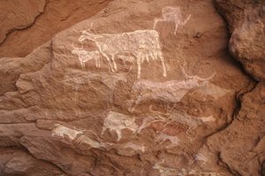 ロックアート、先史時代スーダン、ウワイナット山塊の岩絵（Karkur-TalhまたはKarkur Talh）、装飾されたシェルターにいる牛の集団。紀元前8000年から3000年の時代。写真撮影 作： Unbekannt