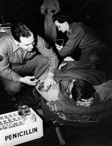 第二次世界大戦（1939-1945） - 第二次世界大戦（WWIIまたはWW2）。1945年2月のルクセンブルグ。米軍の避難病院で、衛生兵（看護師）が負傷した兵士にペニシリンを投与して感染を防ぎ、看護師が手術の準備をしている様子 作： Unbekannt