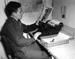 第二次世界大戦（1939-1945） - 第二次世界大戦（WWIIまたはWW2）。1944年12月1日、フランスのムツィヒ（アルザス地方）。Beachead News（GIのニュース誌）の記録係であるCorporal Flanertyが、次号に掲載するピンナップ写真を見ている。 作： Unbekannt